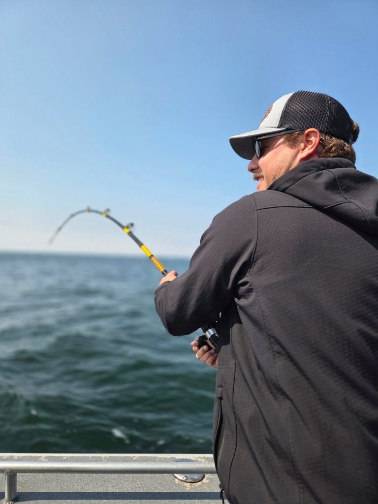 Angler fighting a fish on a bent rod
