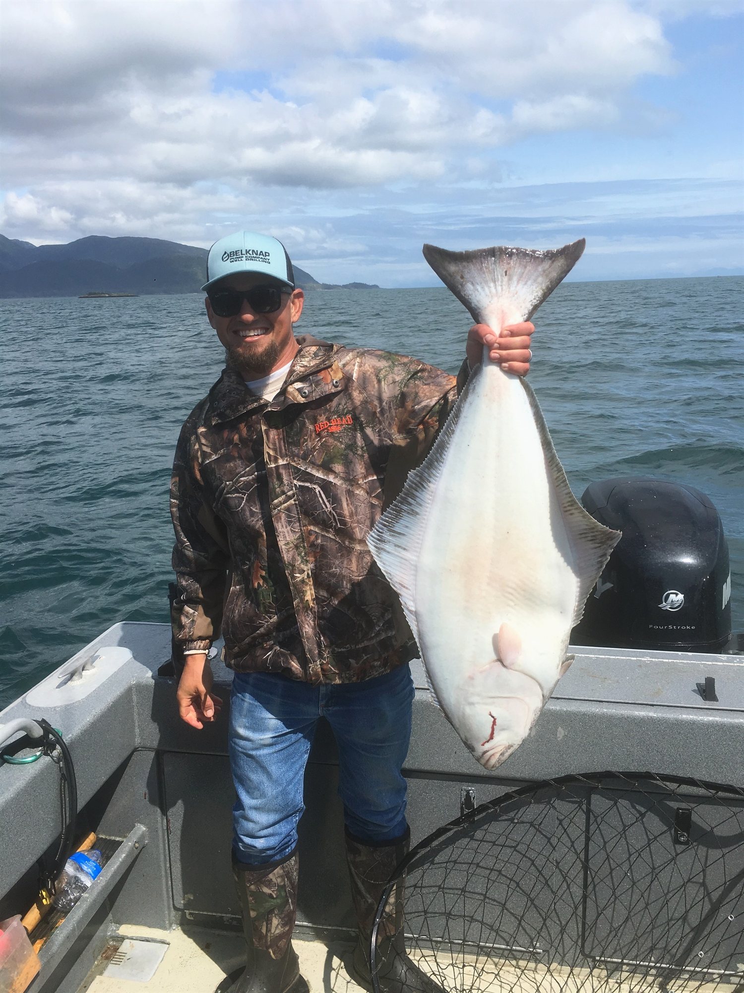 Smiling angler holding up a halibut caught out of Ketchikan