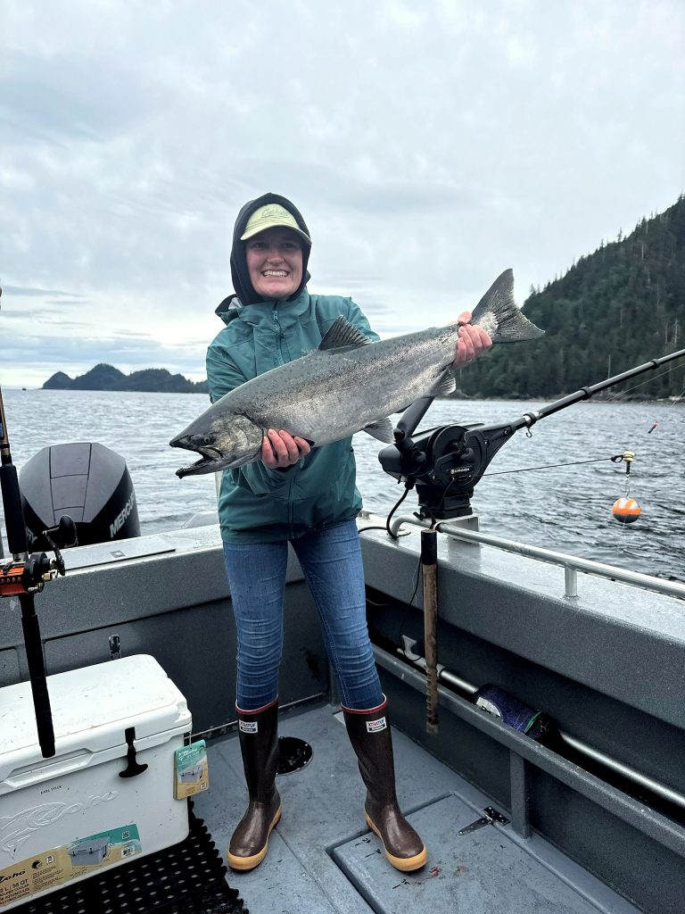 Guest holding a king salmon caught on a Ketchikan fishing charter