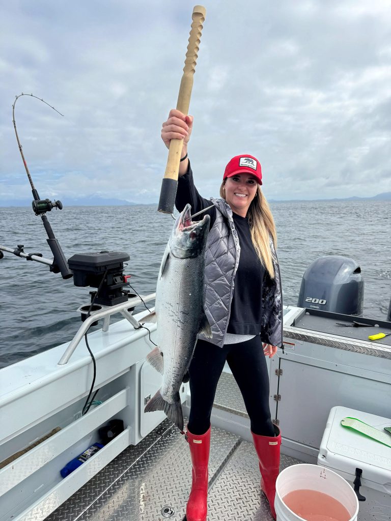 Guest holding a king salmon and the rod that caught it