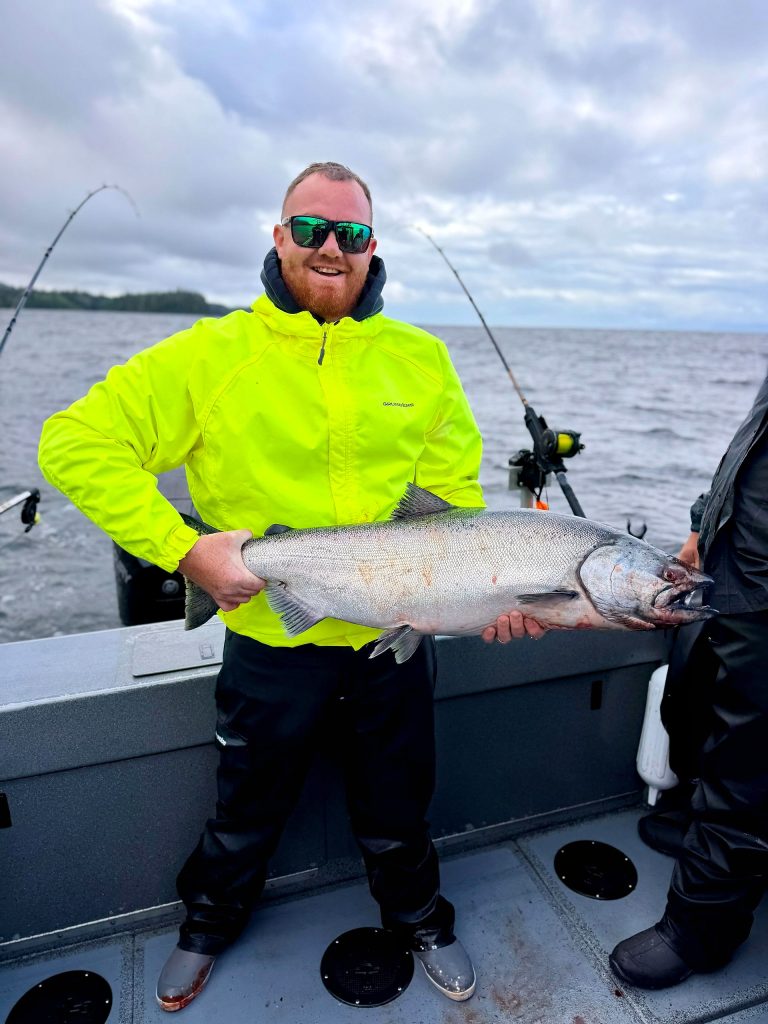 Guest holding a large king salmon aboard the charter boat