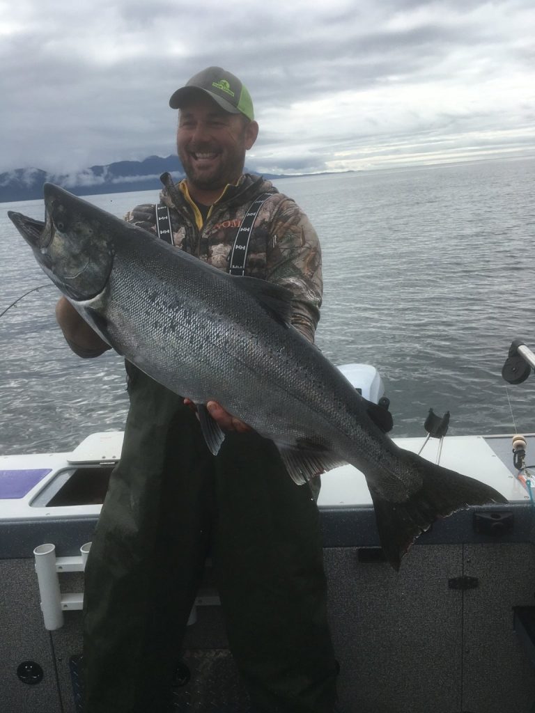 Captain Jim with a large salmon on an overcast day