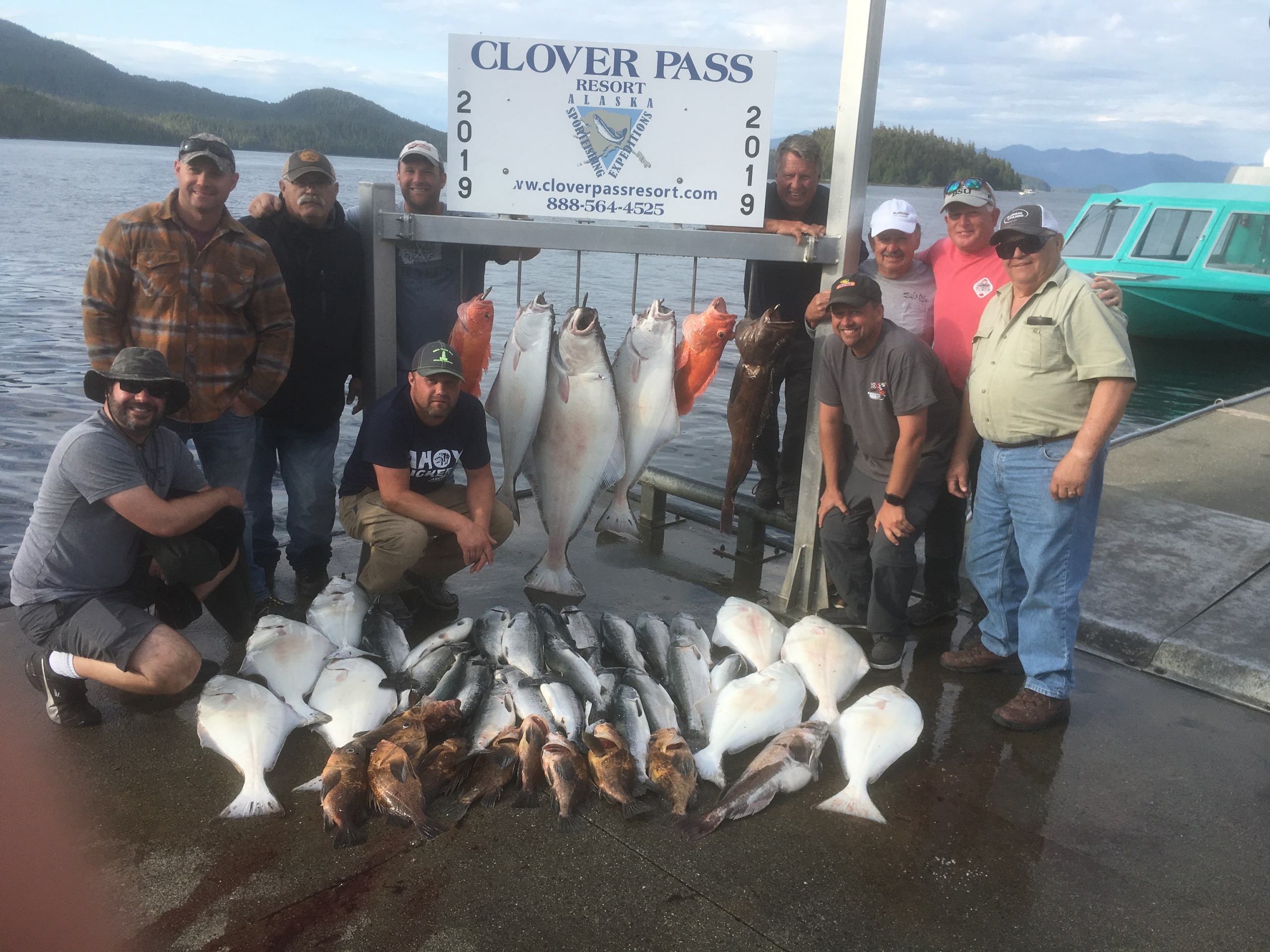 A large group of guests at the Clover Pass dock with a big catch of halibut, salmon, lingcod, and rockfish