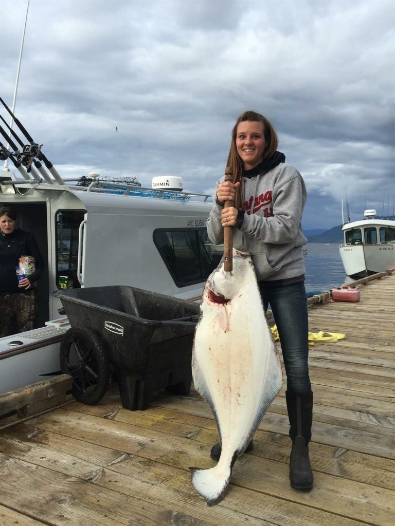 Guest holding a halibut at the Clover Pass dock